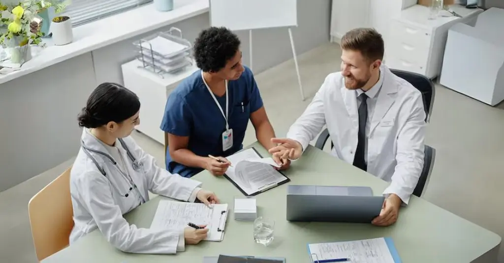Top Challenges Solved By Expert Insurance Credentialing Services Healthcare Professionals Discussing Insurance Credentialing Services And Provider Enrollment Requirements In Medical Office