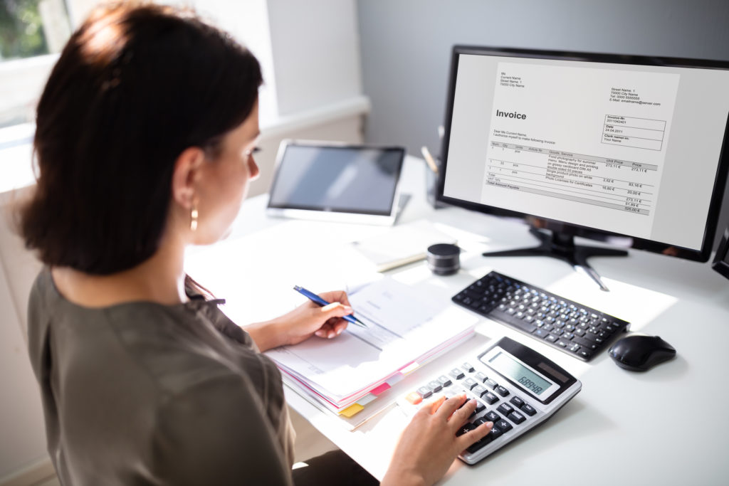 Medical Billing Companies In Illinois – 5 Reasons Providers Trust Us Professional Medical Billing Specialist Working On Invoice Management For Medical Billing Companies In Illinois Using Calculator And Computer